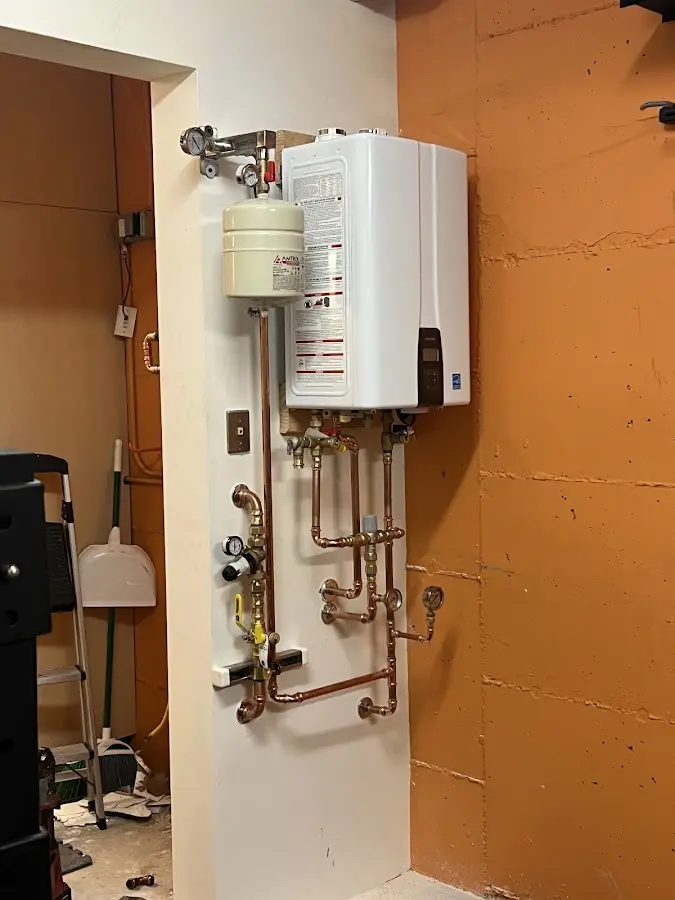 Plumbing technician inspecting water heater connections in Meadowbrook